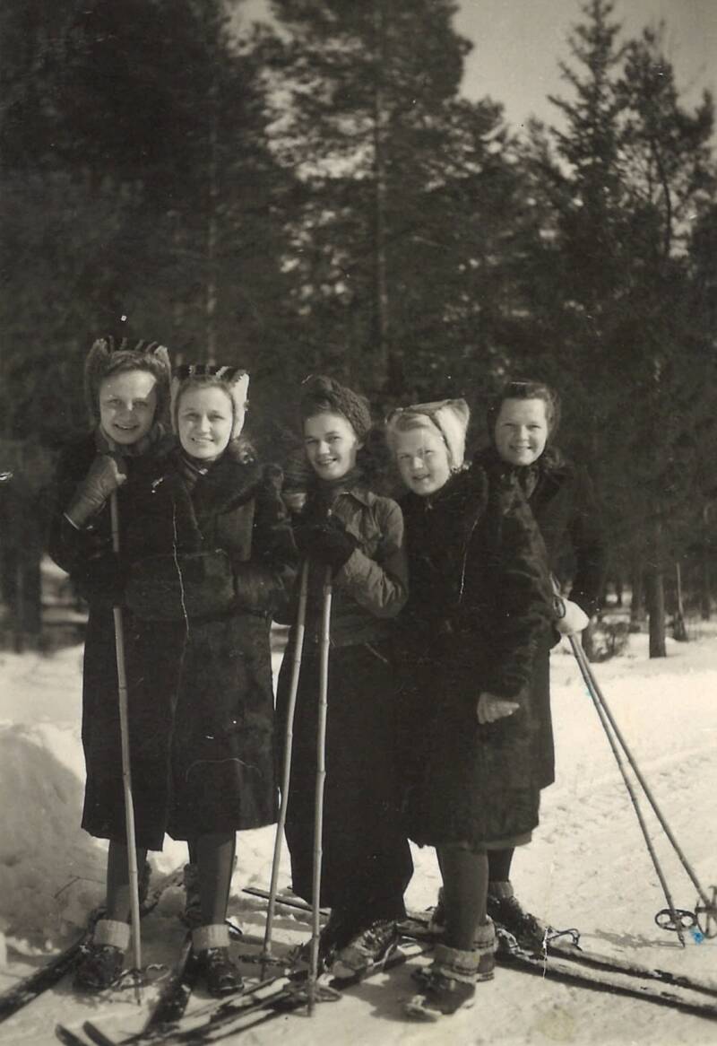 Neljä pikkulottaa ulkona hiihtämässä